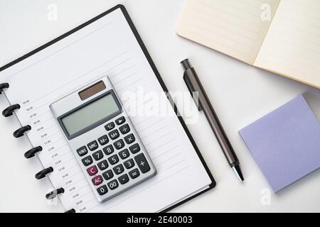 Topview of notebook with pen, calculator and sticky note Stock Photo