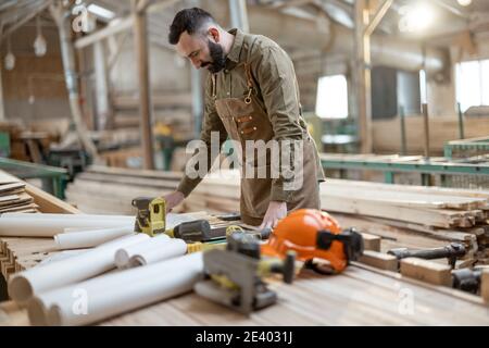 Handsome carpentry worker in the joinery manufacturing Stock Photo