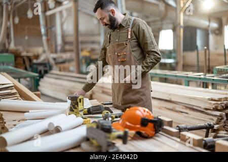 Handsome carpentry worker in the joinery manufacturing Stock Photo