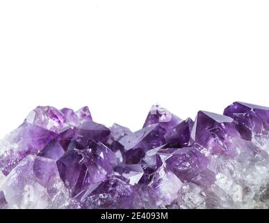 Close up view of large violet amethyst crystal cluster border isolated with white background. Esoteric magical background concept. Stock Photo