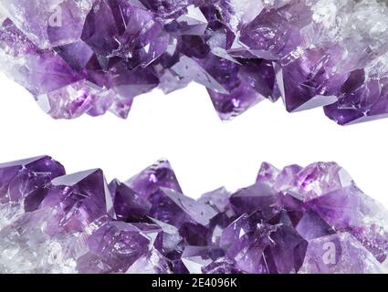 Close up view of large violet amethyst crystal cluster border isolated with white background. Esoteric magical background concept. Stock Photo