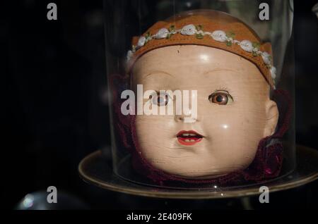 Close-up of an antique dolls head under a bell jar. Stock Photo