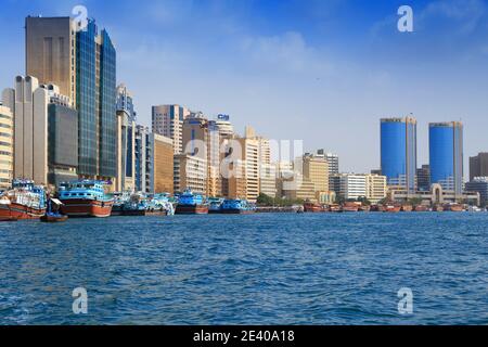DUBAI, UAE - DECEMBER 9, 2017: Dhow wooden cargo ships moored at Dubai Creek port in UAE. Dubai is the most populous city in UAE and a major global ci Stock Photo