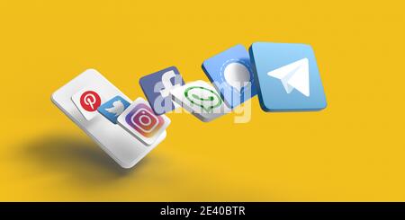 Telegram vs whats app concept. View from above on 3D rendered famous social media application flying icons on yellow background and white mobile phone Stock Photo