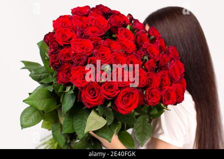 The girl with big bouquet of flower roses on her shoulder Stock Photo