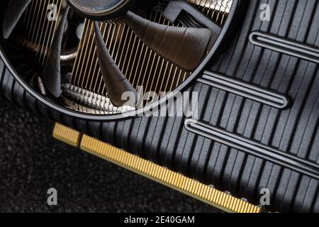 Close-up of graphics card fan and interface PCI E against dark background. Graphics card for gaming and mining. Modern desktop pc  hardware component. Stock Photo