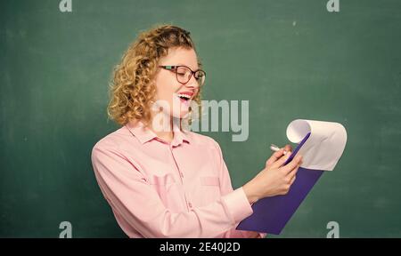 School principal hiring workers. School teacher job position. Read impressing resume. Personal profile. Estimate motivational letters of applicants. School staff. Smart woman hold tablet documents. Stock Photo