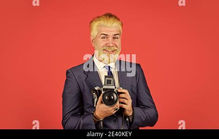 Confident and handsome. professional photographer make photo. male beauty. capture result of barbershop salon. vintage camera. confident businessman hold retro camera. mature man dyed beard and hair. Stock Photo