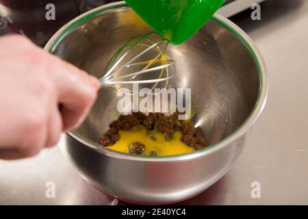 A pile of brown sugar and yolk in steel bowl. Close-up. Stock Photo