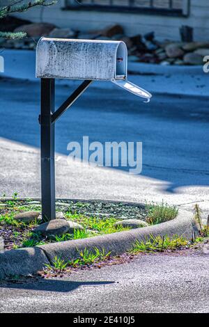 Vertical shot of a lonely old mailbox outside a bankrupt business during the pandemic. Stock Photo