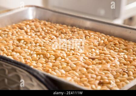 Ready sponge cake with pine nuts in a baking dish. Close-up. Stock Photo