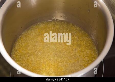 Fresh lemon juice and zest in metal bowl. Close-up. Stock Photo