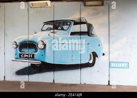 A graffiti style painting of a three wheeled Reliant car on an underpass next to the river Tame in Tamworth. Reliant were a motor car company based in Tamworth. The company ceased to exist in 2002 and the site of the Reliant factory is now a housing estate. The company were well known for their unusual three wheeled vehicles. Stock Photo