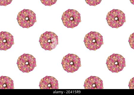 Seamless diagonal pattern with beautiful doughnuts glazed with pink chocolate and peach and pink colored marshmallow hearts on white background. View Stock Photo