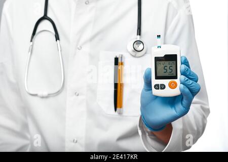 doctor holding glucometer for measuring glucose levels in the patient's blood, close-up Stock Photo