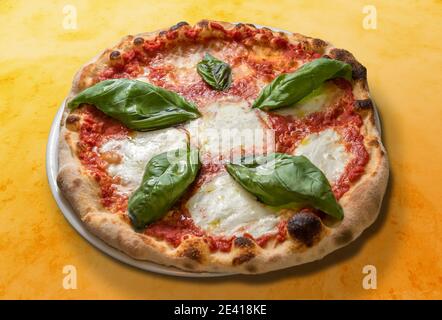 margherita pizza with tomato basil sauce and mozzarella cheese on orange spotted background Stock Photo