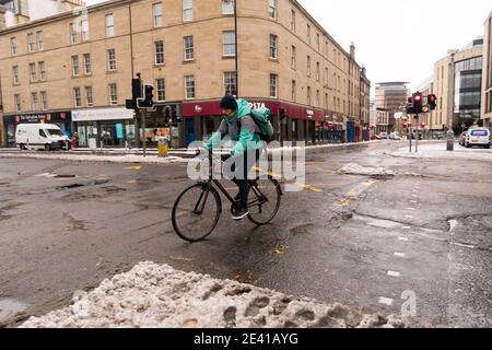 Deliveroo delivery cyclist, cycling the wrong way in Edinburgh city center, Scotland, UK. Stock Photo