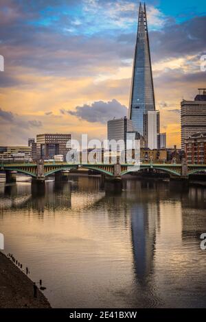 The Shard, Britains tallest building reflects in the unusually still waters of the Thames. Stock Photo