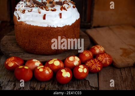Easter cake and colored eggs. Rustic food on a wooden table. Traditional egg colored with onion peel. Clover and dill leaves pattern. Classic food for Stock Photo