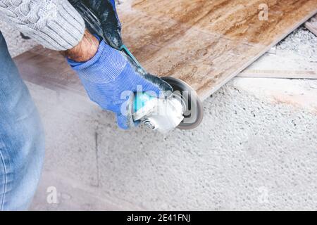the tiler cuts tiles professionally and efficiently with an angle grinder Stock Photo