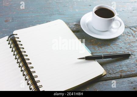 coffee with a notebook and pens on the table Stock Photo