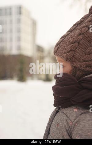Cute little girl in warm clothes outside in winter Stock Photo