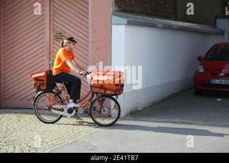 DORTMUND, GERMANY - SEPTEMBER 16, 2020: Postal worker of Postcon company delivers mail by bicycle in downtown Dortmund, Germany. Stock Photo