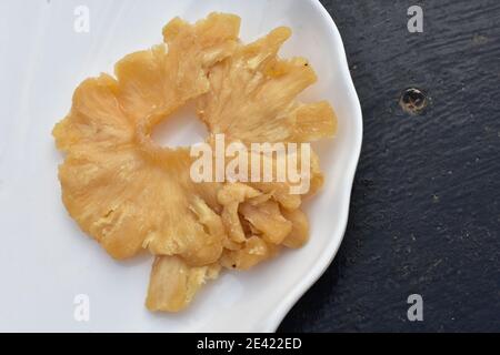 A slice of dried pineapple on white plate Stock Photo