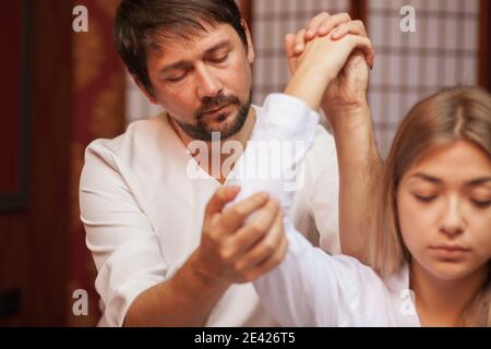 Woman getting thai stretching massage Stock Photo - Alamy