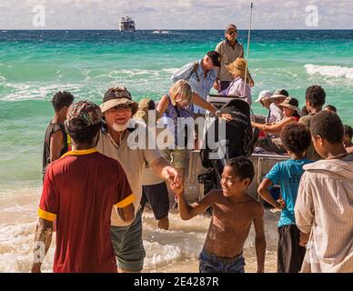 Local people and tourists are meeting on a beach in Papua New Guinea