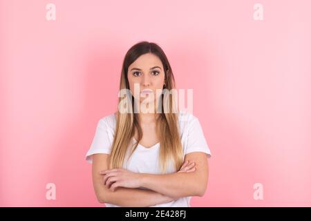 young woman with her arms crossed and a serious look on her face Stock Photo