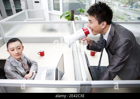 Businessman shouting to a businesswoman using megaphone high quality photo Stock Photo