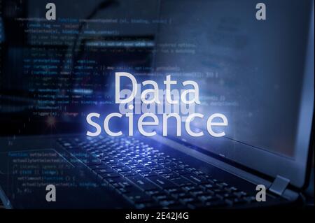 Data science inscription against laptop and code background. Learn data science, computer courses, training. Stock Photo