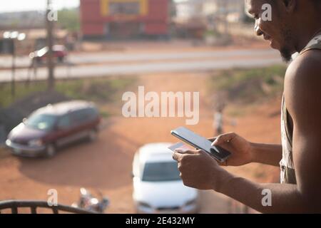 african man using his phone and a credit card Stock Photo