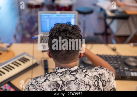 Rear view of young man making music Stock Photo