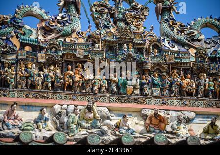 Porcelain dragons and figurines expressing themes from Chinese religion and legends on the roof of Thien Hau Temple, Ho Chi Minh City, Vietnam Stock Photo