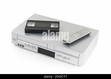 Old video cassette and disk player with tape and remote controller on white. Stock Photo