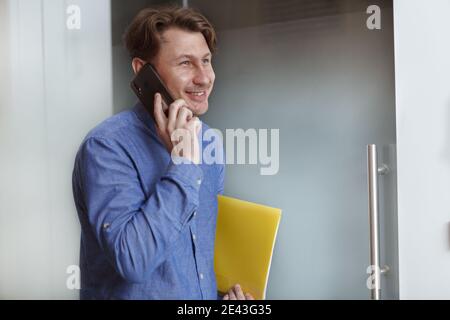 Cheerful mature businessman laughing while talking on the phone Stock Photo