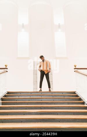 Handsome young bearded hipster black guy with curly hair dressed in casual white shirt looking at camera Stock Photo
