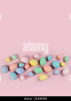 Multicolored Easter eggs and feathers in pastel colors lie on pink background. Copy space. Festive Easter card. Stock Photo