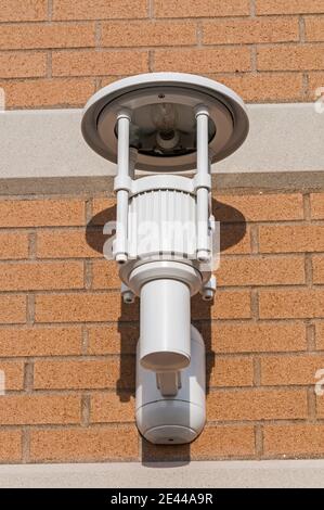 A white plastic lighting fixture on a red brick building. Stock Photo