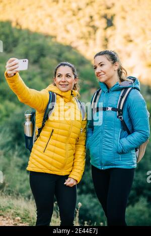 Cheerful hikers taking selfie on smartphone, sitting in tent Stock ...
