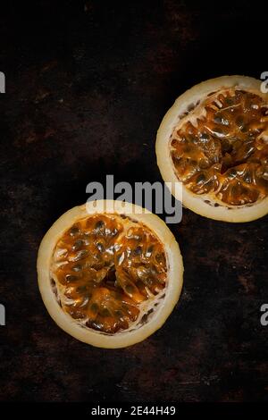 Top view of passion fruit cut in half on dark rustic wooden background Stock Photo