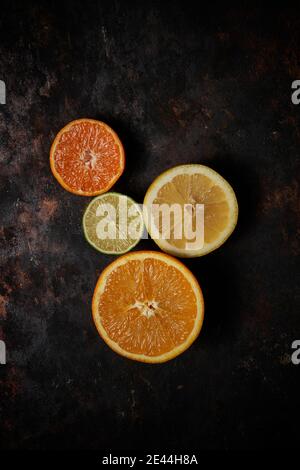 Top view of oranges, tangerines and lemon on dark rustic wooden background Stock Photo