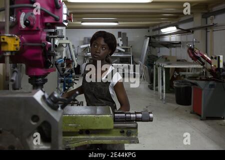 Professional young African American female mechanic processing detail on lathe machine while working in repair workshop Stock Photo