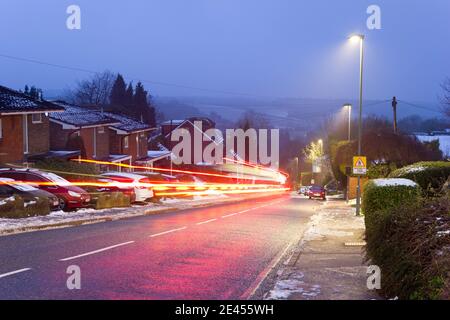 Light trails along a hilly road covered in light snow in winter Bromley England UK Stock Photo