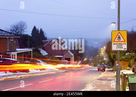 Light trails on a hilly road covered in light snow in winter, Bromley England UK Stock Photo