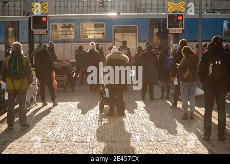 Prague, Czech Republic. 01-21-2021. People waiting for the train to go through so they lift the train barriers, in the center of Prague during a sunny Stock Photo