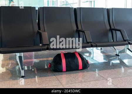 Unattended bag left under chair in the airport or bus or train station. Stock Photo