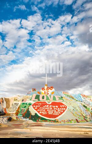 Colorful Salvation Mountain under a cloudy sky in Slab City, California